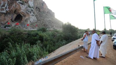 People stand on the Algerian side of the Algeria-Morocco border as Algerian flags sway in the wind and Moroccan flags are seen in the distance, near Tlemcen, at a border post in the Marsat Ben M'Hidi region. Farouk Batiche / AFP