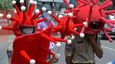 Police at a traffic intersection wearing headgear themed on the Covid-19 coronavirus urge people to adopt safety protocols during an awareness drive in Hyderabad. AFP