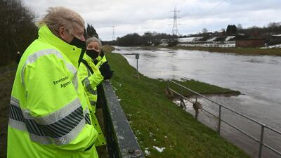 Boris Johnson looks at River Mersey in Didsbury with Environment Agency workers, as Storm Christoph brings heavy rains across the country. AFP