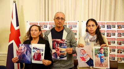 Ayelet Svatitzky, David Barr and Ofri Bibas Levy show pictures of their loved ones who were taken hostage by Hamas. Reuters