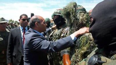The Tunisian president, Moncef Marzouki, centre, greets a soldier at a military camp in the border region with Algeria. AFP