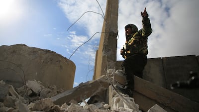 A Kurdish-led Syrian Democratic Forces fighter at a damaged part of the defense wall of Gweiran Prison in Hassakeh. AP