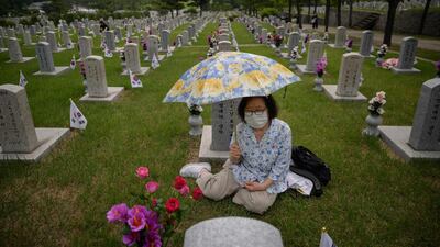 Kim Myung-sook sits before a grave of her brother at the National Cemetery as South Korea marks Memorial Day in Seoul. AFP
