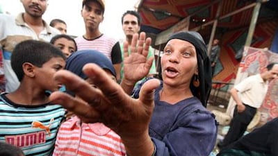 A woman gestures as she talks about the strike by rubbish men in the low-income neighbourhood of Imbaba in Cairo.
