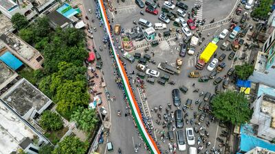 Pupils carry a large Indian national flag during the 'Har Ghar Tiranga' campaign on the eve of the country's Independence Day celebrations in Vijayawada. AFP