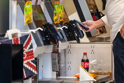 A customer uses their phone to pay inside a Marks & Spencer store in London. Bloomberg