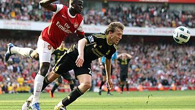 Arsenal's Emmanuel Eboue, left, bundles over Liverpool midfielder Lucas over in the area to earn the visitors a 102nd-minute penalty at Emirates Stadium yesterday.