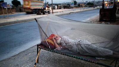 An elderly Pakistani man, who fled his home with his family from Pakistan's tribal areas, due to fighting between the Taliban and the army, sleeps on a bed covered with a mosquito net, on a roadside, on the outskirts of Islamabad, Pakistan. Muhammed Muheisen / AP Photo