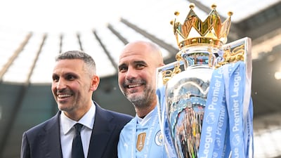 Khaldoon Al Mubarak and Pep Guardiola pose for a photo with the Premier League trophy following the team's victory over West Ham United at Etihad Stadium on May 19, 2024. City made history as the only team in English top-flight history to win four league titles in a row. Getty Images