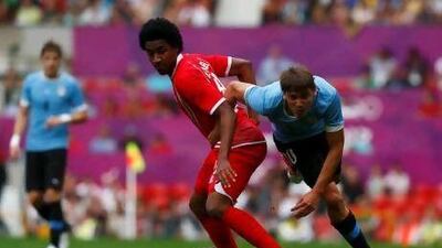 UAE's Amer Abdulrahman, left, fights for the ball with Uruguay's Gaston Ramirez during their men's Group A football match at Old Trafford.