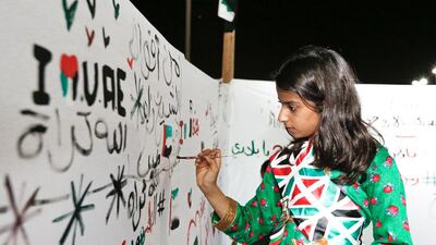 A girl paints her best wishes to the UAE at the 45th National Day celebrations in Sharjah’s National Park. Victor Besa for The National
