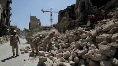 In photo shows Syrian workers remove rubble from damaged shops in the old city of Aleppo, Syria. AP