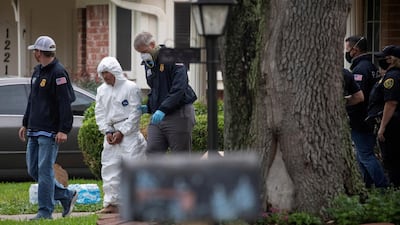 Homeland Security personnel escort a man from a house in Houston, Texas, US. Police had found more than 90 people crammed into a two-storey home, and suspected it was being used in a human smuggling operation. Reuters
