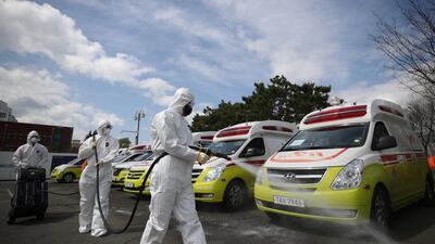 Emergency workers disinfect ambulances used for transferring the novel coronavirus Covid-19 patients in the south-east city of Daegu. EPA