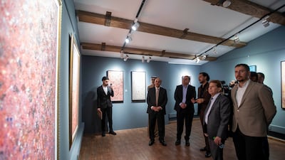 Guests admire the captivating brushstrokes and embossed canvases of Shamma's artworks