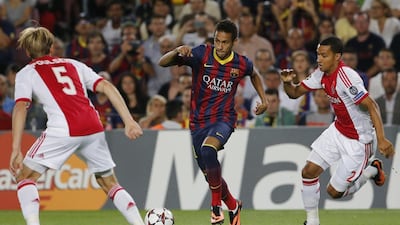Barcelona’s Neymar, centre, tries to pass Ajax’s Christian Poulsen, left, and Ricardo van Rhijn in Spain on Wednesday night. Emilio Morenatti / AP Photo