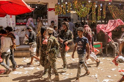 Pro-government fighters walk near the qat market in Marib province. Asmaa Waguih for The National