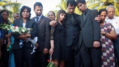 Jacintha Saldanha's widower Ben Barboza (fourth from right) and her children Lisha (fifth from right) and Junal (third from right) stand beside her coffin during her funeral at a cemetery in Shirva.
