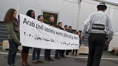 Representatives of NGOs hold a banner to demand 100 per cent renewable energy by 2050 at the COP21, United Nations Climate Change Conference, in Le Bourget north of Paris on Saturday, December 5, 2015. Michel Euler / AP Photo