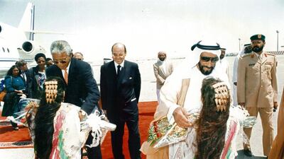 Emirati girls give gifts to Sheikh Zayed and South African president Nelson Mandela during his UAE state visit.
