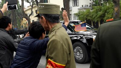 People wave as the motorcade with President Donald Trump makes it way through the streets in Hanoi, Vietnam. AP Photo