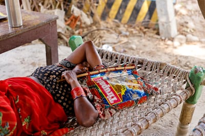 A farm labourer sleeps on a bed along with a handmade fan under a shed at her house on the field at the Yamuna floodplains on a hot summer day during a heatwave in New Delhi in May. Reuters
