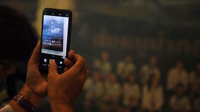 This picture shows a visitor taking photos of a mural illustrating the rescue of the members of the “Wild Boars” football team. AFP