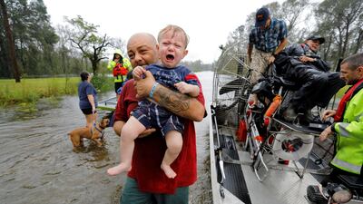 Oliver Kelly, a 1 year old, cries as he is carried off the sheriff's airboat during his rescue from rising flood waters in the aftermath of Hurricane Florence in Leland, North Carolina. Reuters