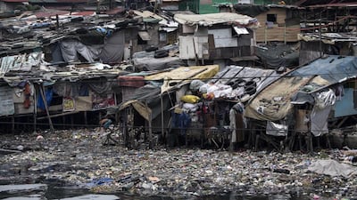 Residents reinforce the roof of their house by putting heavy tires at a slum area in Manila. Noel Celis / AFP