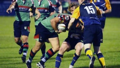 Nick McBride of the Abu Dhabi Harlequins pushes for a try against James Tometski (15) and Chris Gregory of the Dubai Hurricanes. The Quins won 48-24 at The Sevens in Dubai.