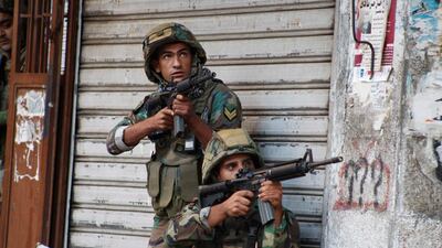 Lebanese army soldiers carry their weapons during clashes with militants in Tripoli on October 25, 2014. Reuters