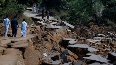 Residents walk alongside a section of road damaged by a powerful earthquake in Jatlan, near Mirpur in north-east Pakistan on September 25, 2019. AP Photo