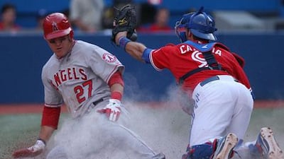 Mike Trout of the Los Angeles Angels slides home safely beating the tag by Toronto's J.P. Arencibia