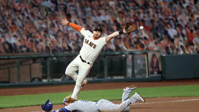 Los Angeles Dodgers' Justin Turner safely steals third base as the ball gets past Evan Longoria of the San Francisco Giants in the Major League Baseball match at Oracle Park on Tuesday, August 25. AFP