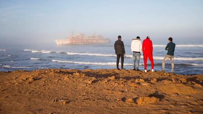 Hassan Boulahcen, 27, a surf coach at Nuevas Olas surf club, Salim Maatoug, 26, the president of Nuevas Olas surf club, Hossin Ofan, 34, the club's general co-ordinator, and Oussama Segari, 26, who works as the club's treasurer and coffee shop manager, check out the waves in front of the Armas shipwreck in Tarfaya, Morocco. "We have a deal here. Everyone who leaves Tarfaya has to come back and do something for the town," Mr Maatoug says. Reuters