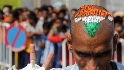 An Indian Cricket fan sports a haircut in national colours as fans wait for tickets for the World Twenty20 World Cup match between India and Pakistan outside the Eden Gardens ground in Kolkata, eastern India, on Saturday. Piyal Adhikary / EPA