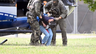 Members of a special police unit escort a man suspected to be responsible for the Solingen knife attack from a helicopter to the office of the Federal Prosecutor in Karlsruhe, southern Germany. AP