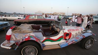 Omani residents takes picture of Mercedes Benz model 1929 vintage auto, with decals bearing the image of the country's leader Sultan Qaboos bin Said, during an annual classic car show in the capital Muscat. Mohammed Mahjoub / AFP Photo