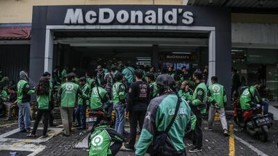 Food delivery riders make their way into a McDonald’s outlet in Bogor, Indonesia on June 9, 2021, to pick up orders of the new BTS Meal, causing more than a dozen McDonald's outlets to temporarily close over Covid-19 fears. AFP