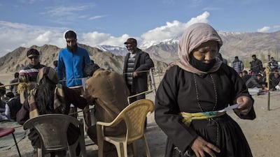 Indian election workers check voting machines before leaving a central collection point for polling stations.