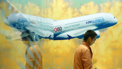 A man walks past an Airbus A380 poster at the Beijing International Aviation Expo in Beijing. The company sees demand for its superjumbo growing in the long term. Wang Zhao / AFP