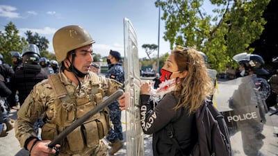 A Lebanese soldiers scuffles with an anti-government protester outside a military court in Beirut, Lebanon. AP
