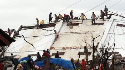 Residents climb on a damaged warehouse belonging to the National Food Authority as they search for food in the aftermath of Typhoon Haiyan in Alangalang, Leyte, Philippines. Jeoffrey Maitem / Getty Images