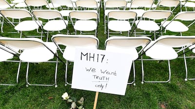 A protest sign in front of a row of empty chairs lined up outside the Russian Embassy in The Hague, Netherlands on March 8, 2020 by family members of victims of the MH17 crash. Each chair represents a seat on the plane. Reuters