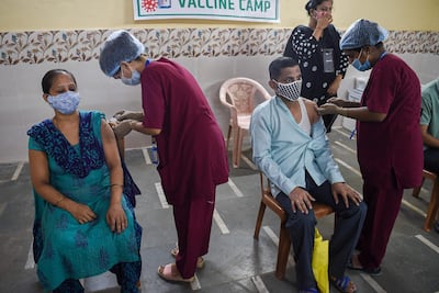 Residents get inoculated with a dose of the Covishield, AstraZeneca-Oxford's Covid-19 coronavirus vaccine, at a vaccination centre in the Dharavi slums in Mumbai on June 29, 2021. / AFP / Punit PARANJPE