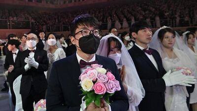 A couple wearing protective face masks attend a mass wedding ceremony organised by the Unification Church at Cheongshim Peace World Center in Gapyeong. AFP