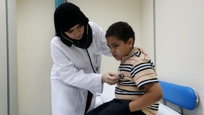 Dr Amal Al Saberi, a second-year family medicine resident, examines 10-year-old Yousef Mamdouh at the Nad Al Hamar health centre in Dubai. Christopher Pike / The National