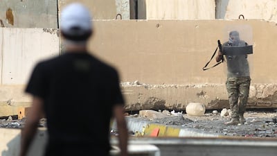 An Iraqi protester stands opposite of a riot policeman amid clashes at Baghdad's Khallani square during ongoing anti-government demonstrations. AFP