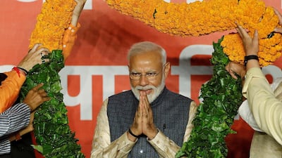 Prime Minister Narendra Modi gestures as he is presented with a garland by BJP leaders in New Delhi after winning India's general election. Reuters