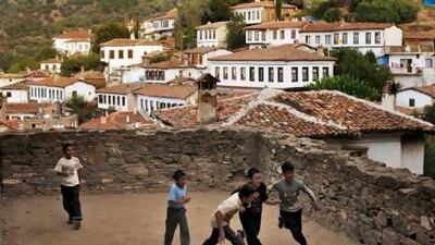Children play football on the grounds of a church in Sirince, where people are flocking to in December to escape doomsday.